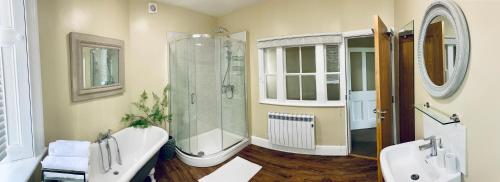 a bathroom with two sinks and a shower and a tub at Hassop Station rooms on the Monsal Trail in Bakewell