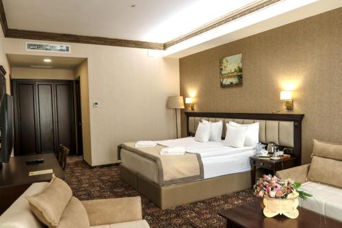 a hotel room with a bed and a couch at Konyak Hotel in Yerevan