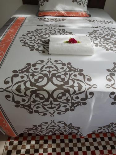 a white bed with a black and white patterned mattress at Maison Cattleya Selfcatering Apartment in Mahe