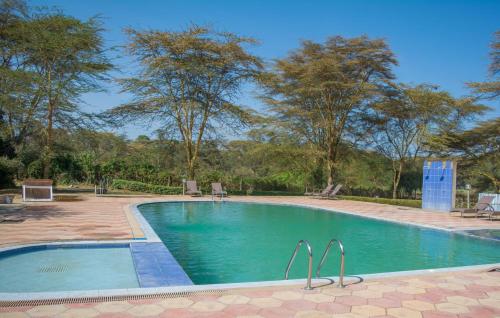 uma piscina num resort com árvores ao fundo em Burch's Resort Naivasha em Naivasha