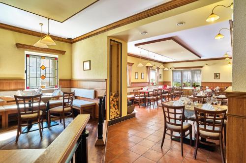 un restaurante con mesas y sillas en una habitación en Hotel Eisensteiner Hof en Bayerisch Eisenstein