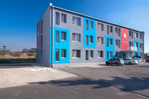 布拉提斯拉瓦的住宿－布拉迪斯拉發加尼飛行員酒店，一座蓝色灰色的建筑,设有停车场