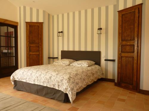 Schlafzimmer mit einem Bett und gestreiften Wänden in der Unterkunft Domaine du Chêne Crucy in Liré