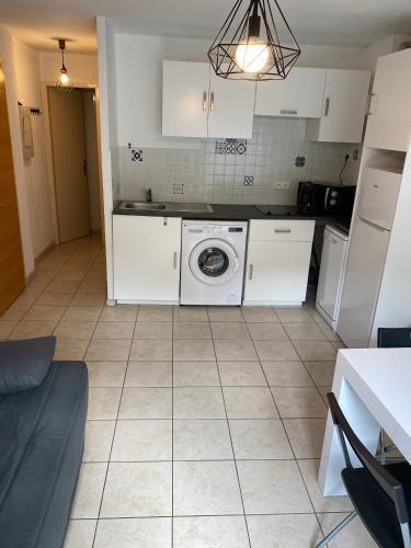 een keuken met een wasmachine bij Appartement 4 couchage Saint Lary Soulan in Saint-Lary-Soulan