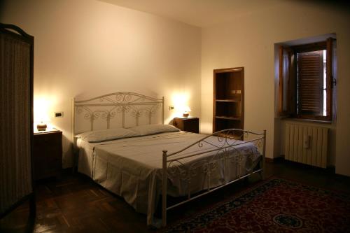 1 dormitorio con cama blanca y ventana en Maison Vannina, en Marsciano