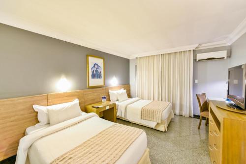 Un pat sau paturi într-o cameră la Plaza Inn Executive
