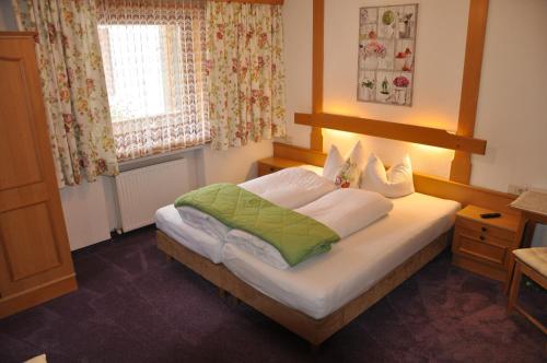 a bedroom with a bed and a window at Pension Lenz in Ischgl