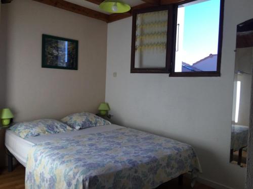 a bedroom with a bed and two windows at Les Mas De La Mer in Port-la-Nouvelle