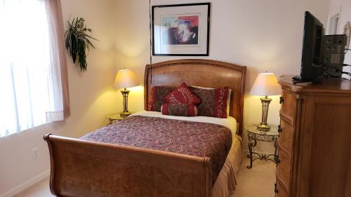 a bedroom with a bed and two lamps and a television at Orlando Discount Villas - Davenport in Davenport