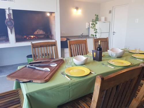 una mesa con un mantel verde con platos y palillos en el 108 y El Mar de Villa Gesell