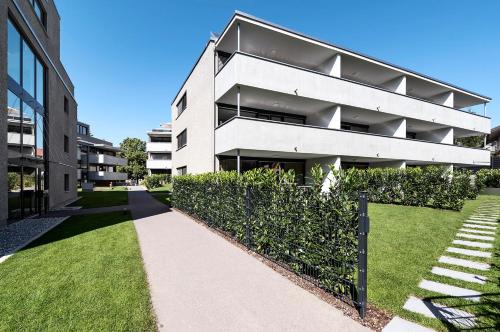 an apartment building with a sidewalk in front of it at Relaxed Urban Living - Aparthotel und Boardinghouse in Dornbirn