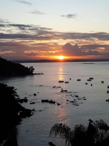 a sunset over a body of water with boats at Casas Coloniais in Morro de São Paulo