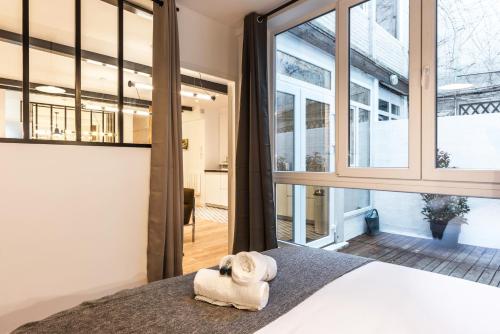 une chambre avec un lit et de grandes fenêtres dans l'établissement Design & New Loft in heart of Paris, à Paris
