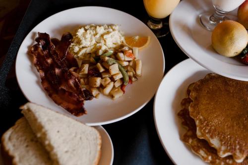 a table topped with plates of food with breakfast foods at Lake Arrowhead Resort & Spa in Lake Arrowhead