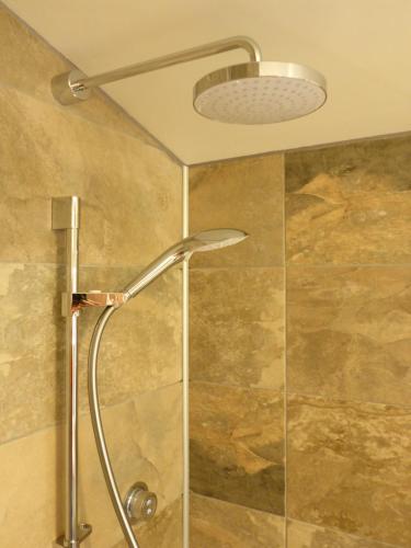a shower with a shower head in a bathroom at Stones Luxury B&B with hot tub and self-contained rooms in Uig