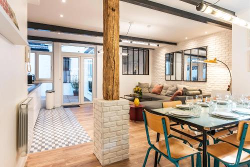 une salle à manger et un salon avec une table et des chaises dans l'établissement Design & New Loft in heart of Paris, à Paris