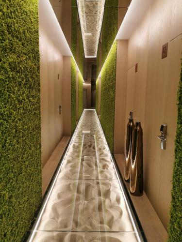 a hallway with a green wall and a long aisle at Playa Grande by Tropical - Adults Only in Gavà