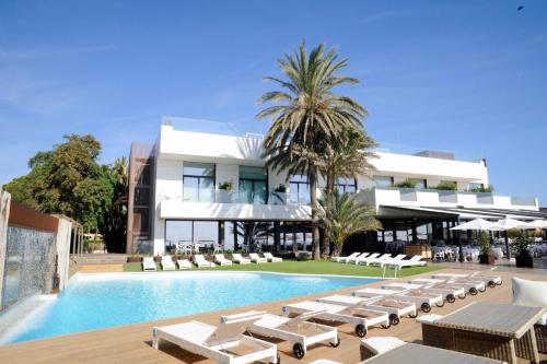 a resort with a swimming pool and lounge chairs at Playa Grande by Tropical - Adults Only in Gavà