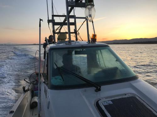 a boat in the water with the sunset in the background at B&B MIKAWA 2 - Kanazawa Fish Harbour in Kanazawa