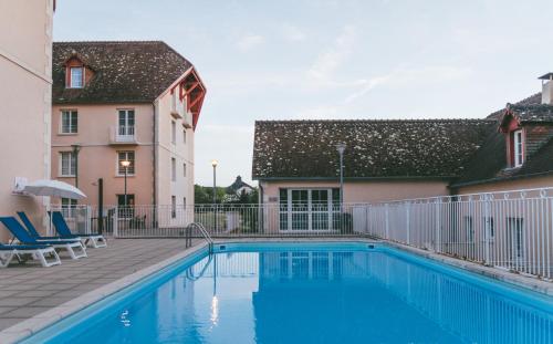 une piscine en face d'un bâtiment dans l'établissement Terres de France - Appart'Hôtel La Roche-Posay, à La Roche-Posay