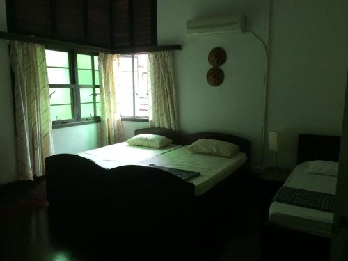 a small bedroom with a bed and a window at The Fairview Guesthouse in Kuching