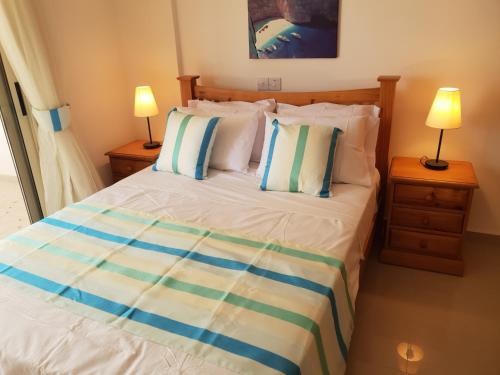 - une chambre avec un lit avec des oreillers et 2 lampes dans l'établissement Ground floor One Bedroom Apartment, Vanessa Complex, à Peyia