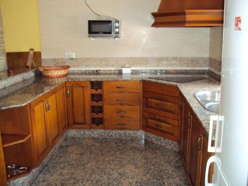 a kitchen with wooden cabinets and a sink at Entre Pinos in El Palmar