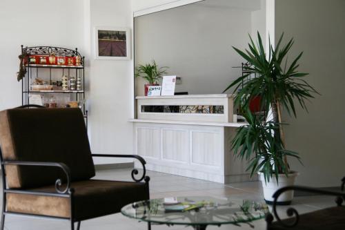a living room with a chair and a table at Lagrange Vacances L’Oustau de Sorgue in LʼIsle-sur-la-Sorgue