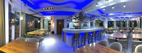 a bar in a restaurant with blue lighting at Villa Manos Hotel in Karterados