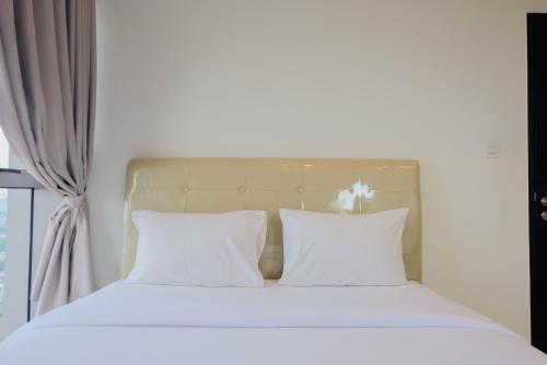 タンゲランにあるComfy and Elegant 1BR Branz BSD Apartment By Travelioの窓際のベッド(白いシーツ、枕付)