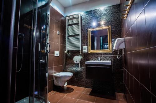 bagno con servizi igienici, lavandino e specchio di Mohito Hostel a Cracovia