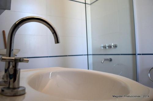 a sink with a faucet in a bathroom at Hotel y cabañas FATVIAL 4 de Abril in Tanti