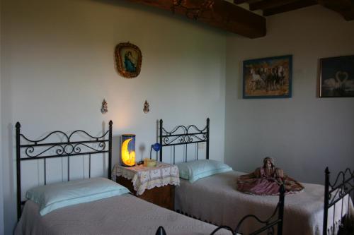 una camera con due letti e un tavolo con una lampada di Casetta i Ciliegi a Cortona