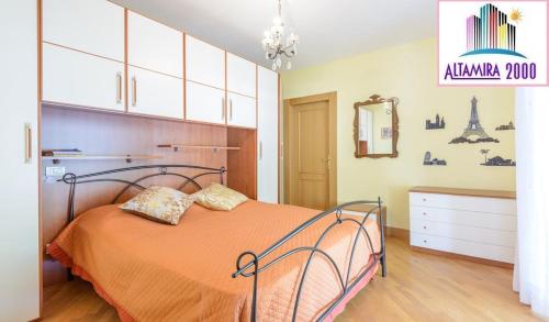 a bedroom with a bed with an orange bedspread at Altamira 2000 by GABRIELLA in Rome