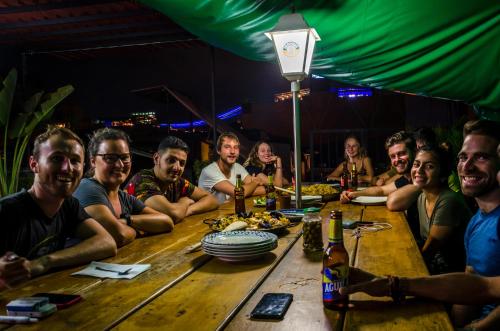 a large group of people sitting at a table at The Sugar Cane Hostel in Medellín