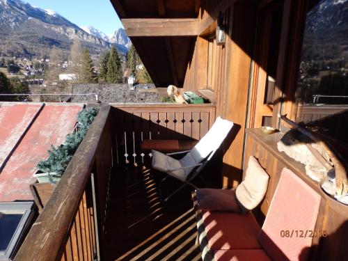 a balcony with a chair and a view of a mountain at Mansarda in chalet a Cortina in Cortina dʼAmpezzo