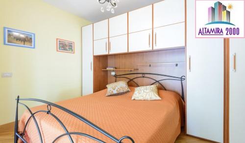 a bedroom with a bed with an orange bedspread at Altamira 2000 by GABRIELLA in Rome