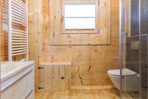 a wooden bathroom with a toilet and a window at TatryTop Osada Luxury Chalets Kościelisko in Kościelisko