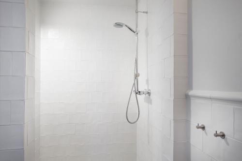 y baño con ducha con cabezal de ducha. en Ódinsvé Hotel Apartments, en Reikiavik