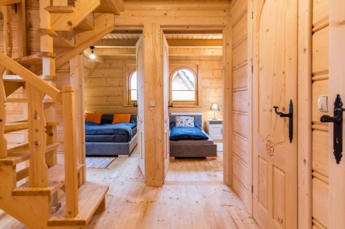 a log cabin with a staircase and a bedroom at TatryTop Osada Luxury Chalets Kościelisko in Kościelisko