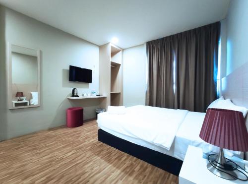 a hotel room with a bed and a television at Princess Hotel Pontian in Pontian Kecil