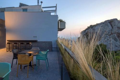 a rooftop patio with tables and chairs and a mountain at The Duke Boutique Suites in Athens