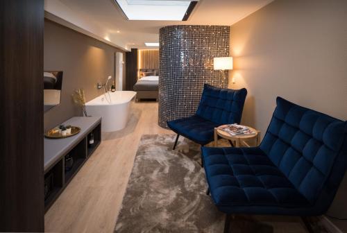 een badkamer met een blauwe bank en een bad bij B&B Centrum Hengelo in Hengelo