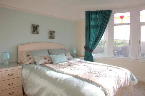 a bedroom with a large bed and a window at Langdale House in St Austell
