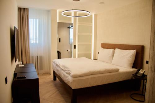 a bedroom with a bed and a lamp at Red & Blue Design Hotel Prague in Prague