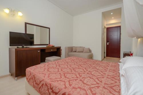 a bedroom with a bed and a flat screen tv at Aeolis Boutique Hotel in Naxos Chora