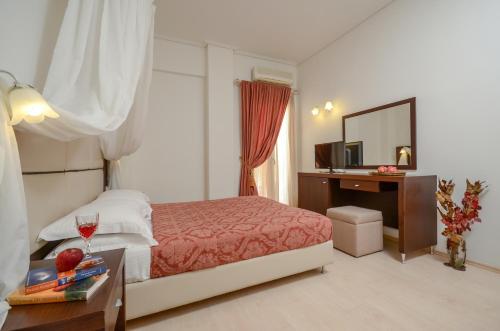 a bedroom with a bed and a desk with a mirror at Aeolis Boutique Hotel in Naxos Chora
