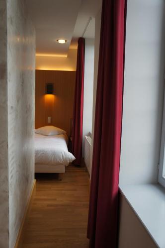 a bedroom with a bed and a red curtain at Hôtel-Restaurant Mont Sainte-Odile in Ottrott