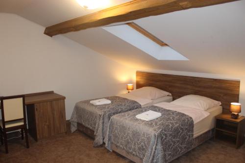 a bedroom with two beds with white sheets at Natura Park in Baligród