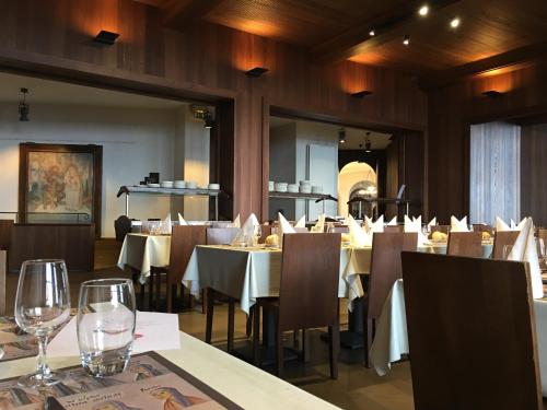 uma sala de jantar com mesas e cadeiras com copos de vinho em Hôtel-Restaurant Mont Sainte-Odile em Ottrott